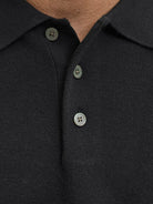 Close-up of a black polo shirt with buttons