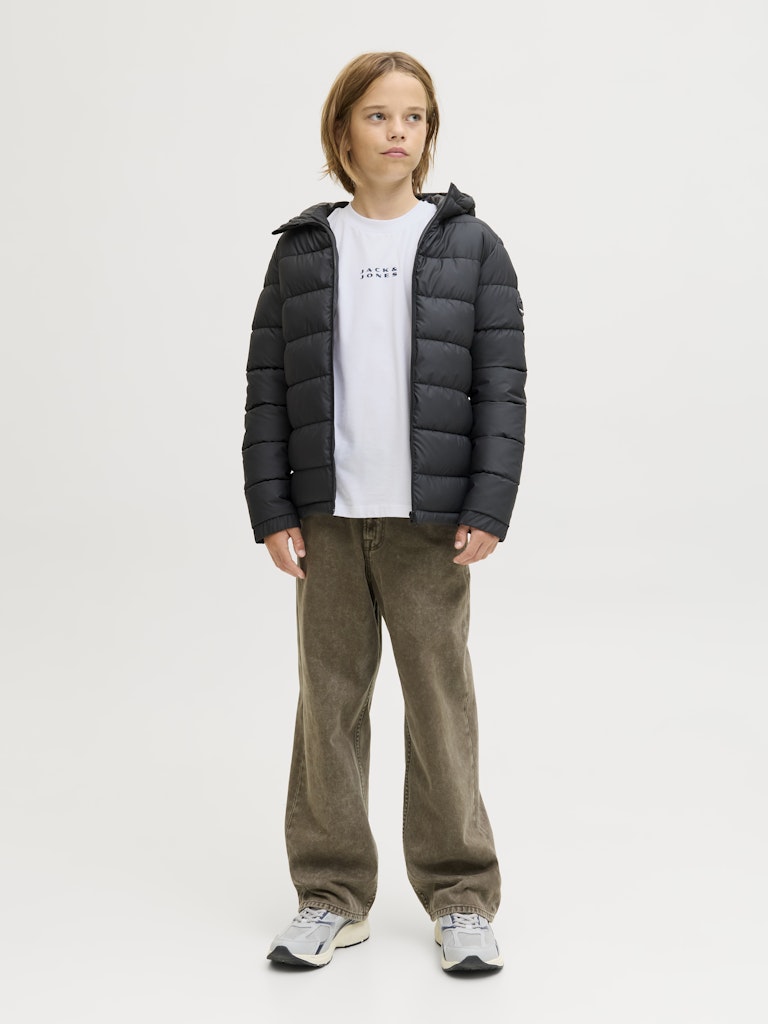 Person wearing a black puffer jacket, white t-shirt, and brown pants on a white background