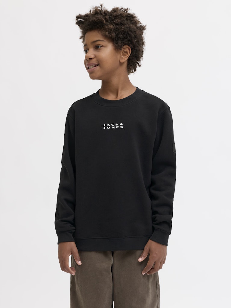Child wearing a black sweatshirt with 'Jack & Jones' logo on a white background