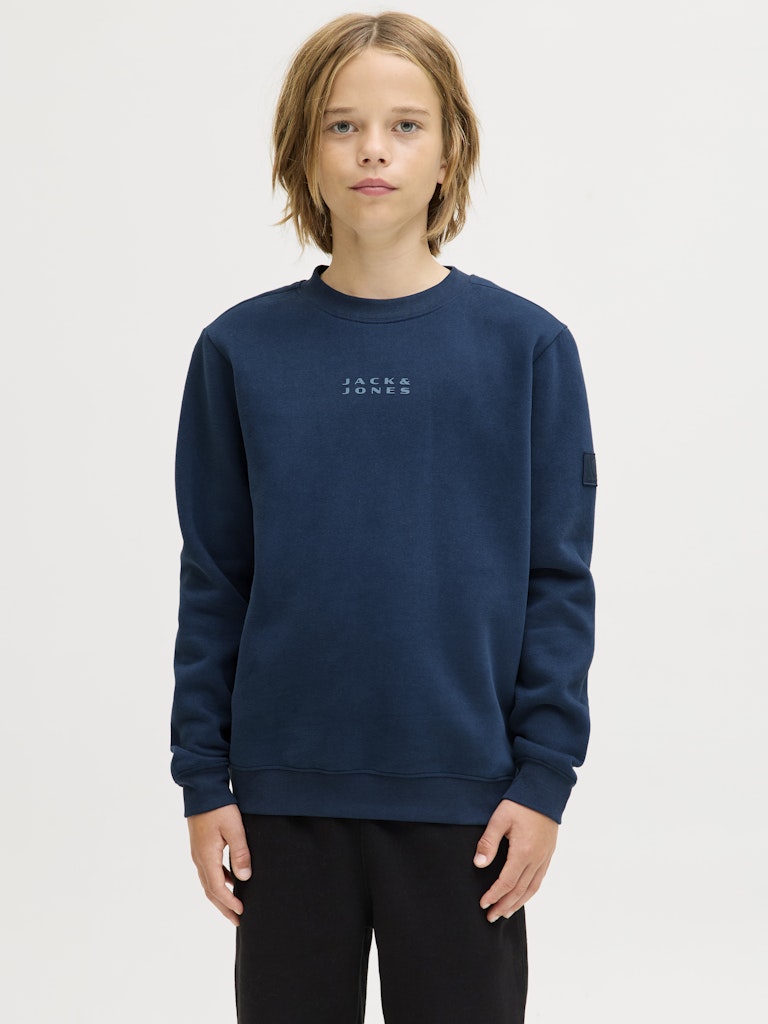 Person wearing a navy blue 'Jack & Jones' sweatshirt on a light gray background