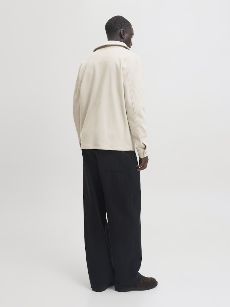 Man wearing a beige cardigan overshirt from behind