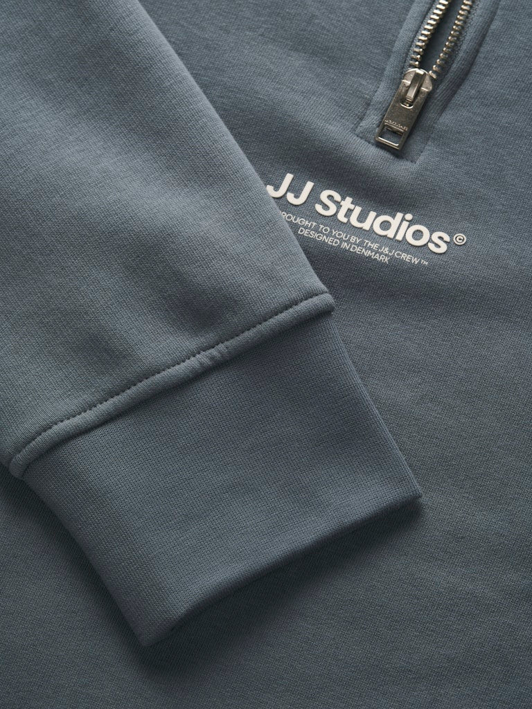 Close-up of a gray sweatshirt with 'JJ Studios' logo on the chest.