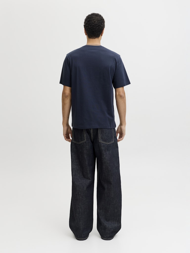 Man wearing a navy short sleeve tee with a jack & Jones logo on the chest-Back view