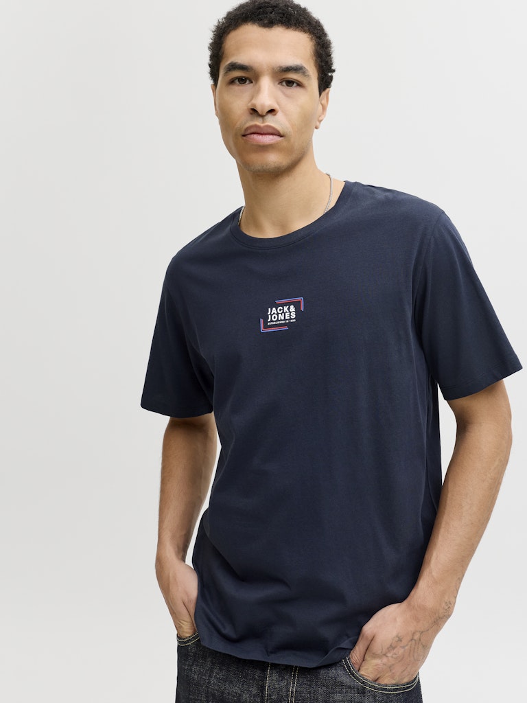 Man wearing a navy short sleeve tee with a jack & Jones logo on the chest-Side view