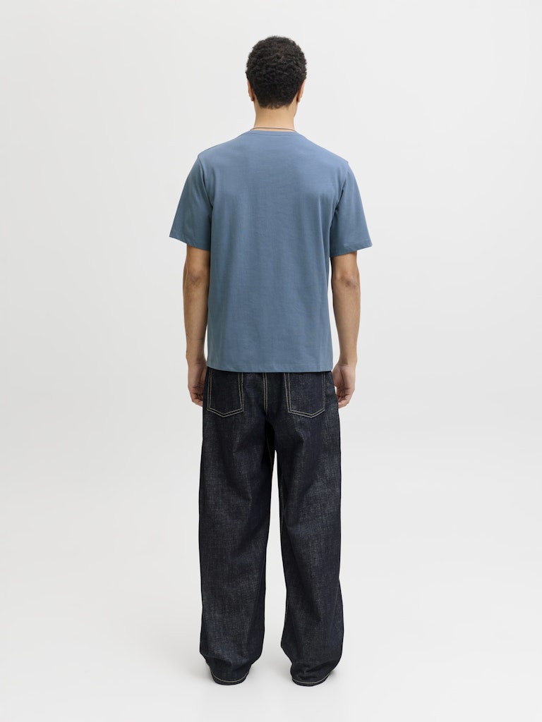Man wearing a blue short sleeve tee with a jack & Jones logo on the chest-Back view
