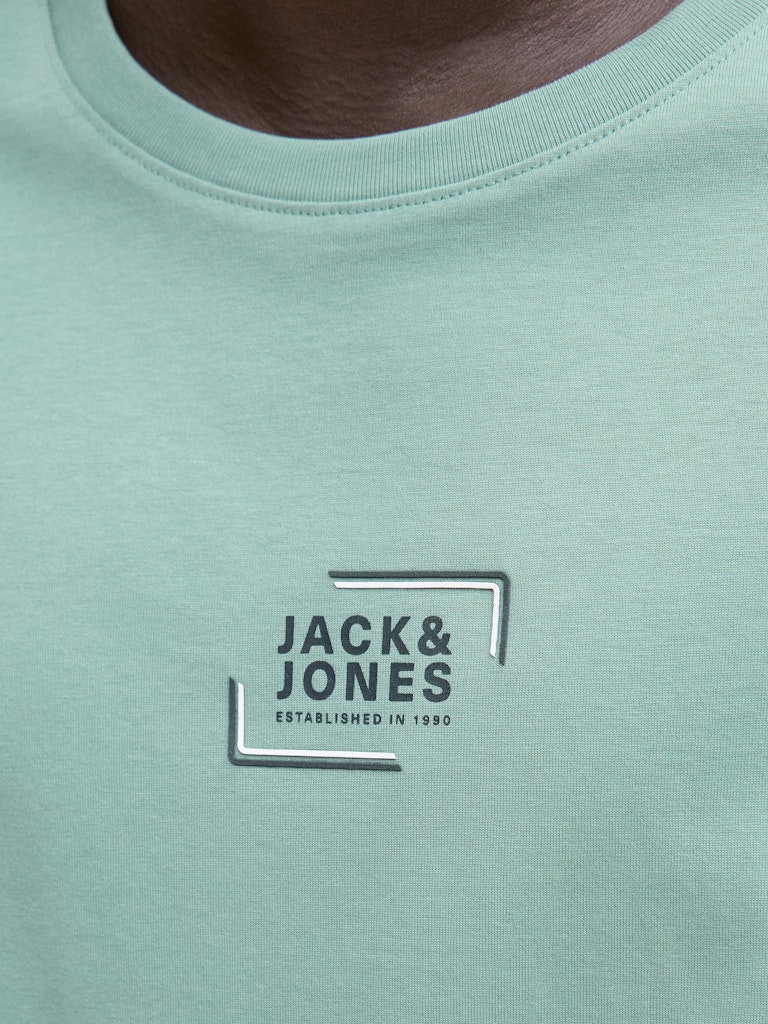 Close-up of a light green t-shirt with Jack & Jones logo.