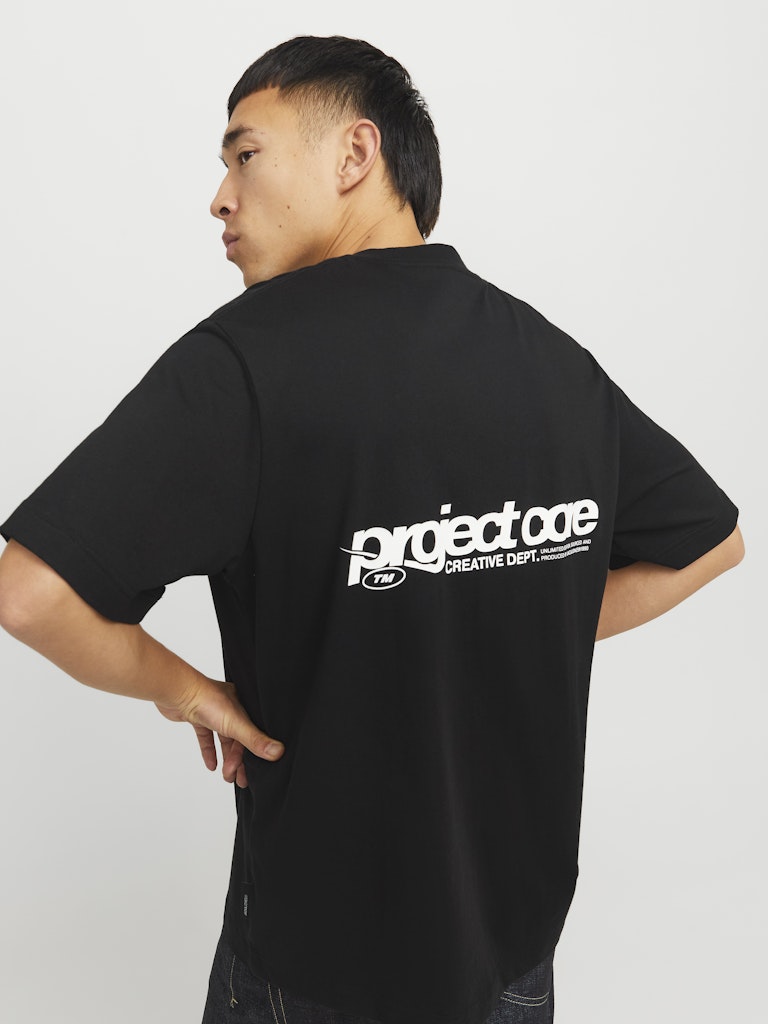 Person wearing a black t-shirt with 'project code' logo on the back against a plain background
