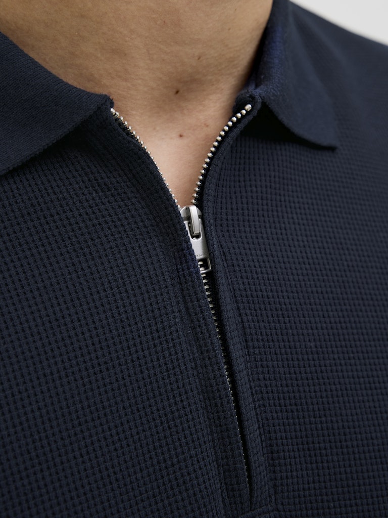 Navy blue textured zip-up polo shirt with a close-up of the zipper.