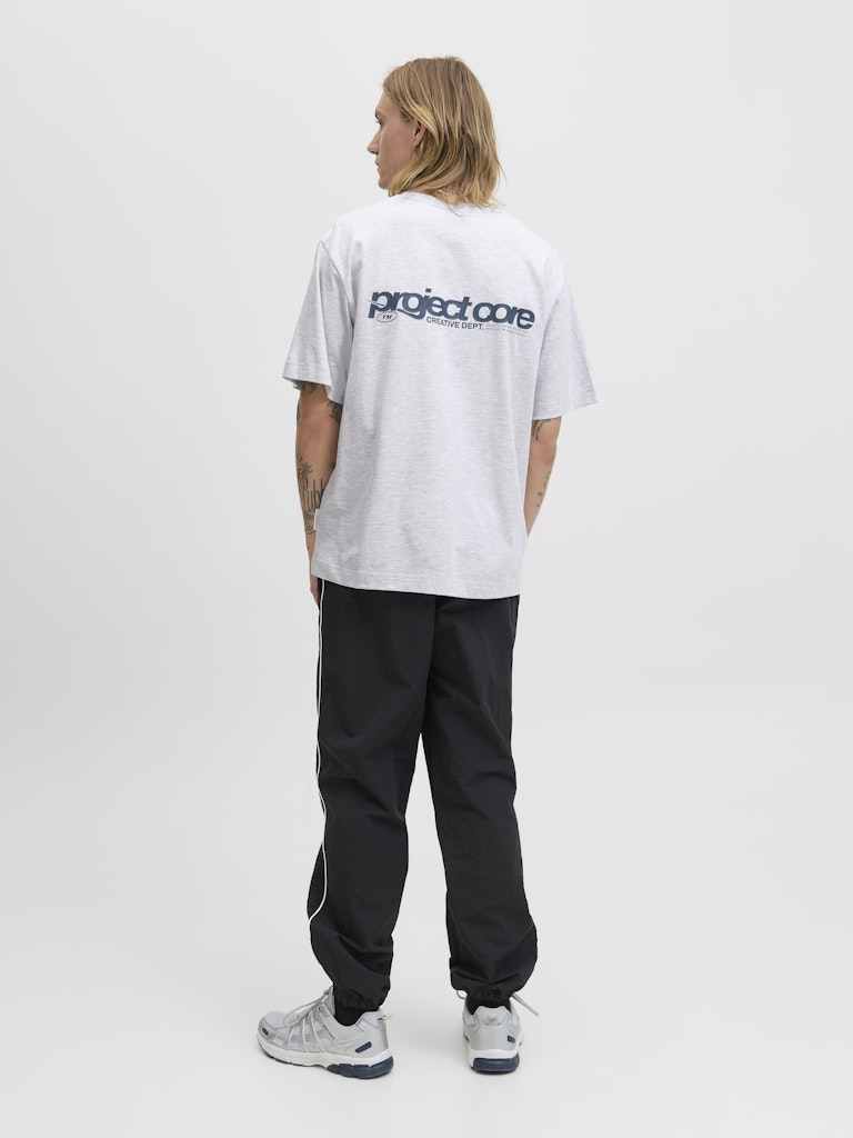 Person wearing a white 'project core' t-shirt and black pants on a white background