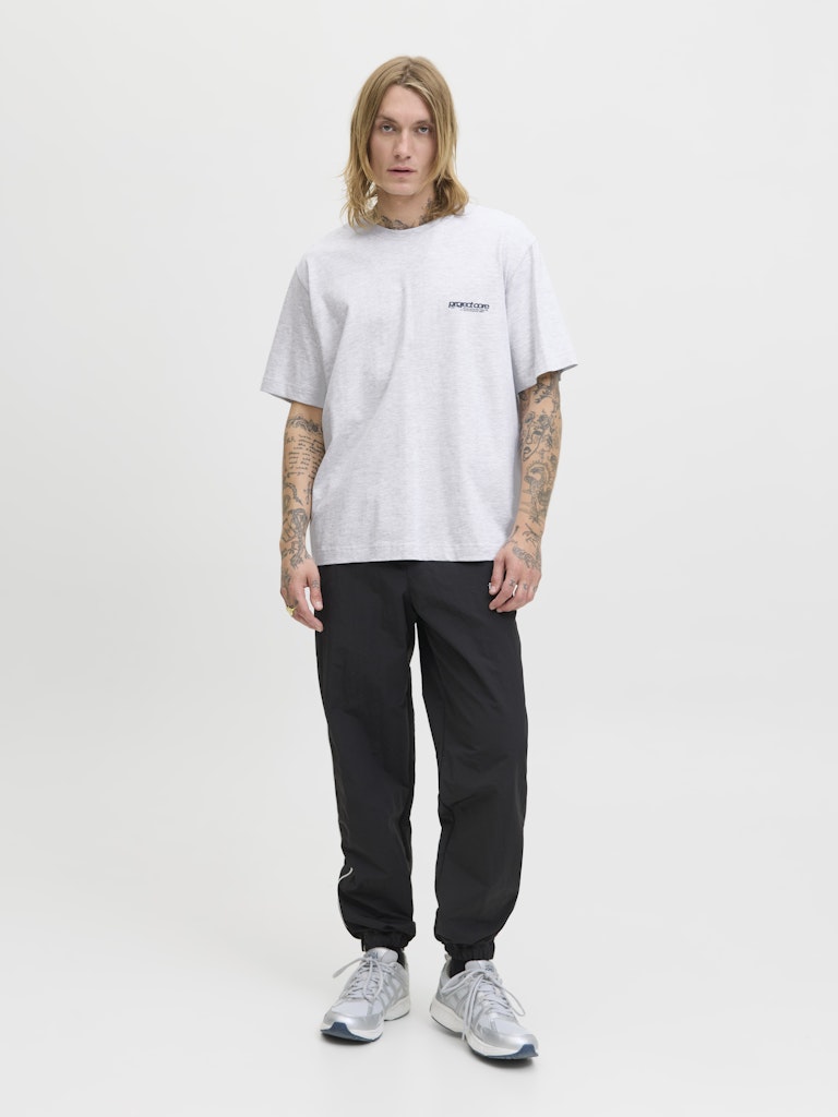Person wearing a white t-shirt and black pants on a white background