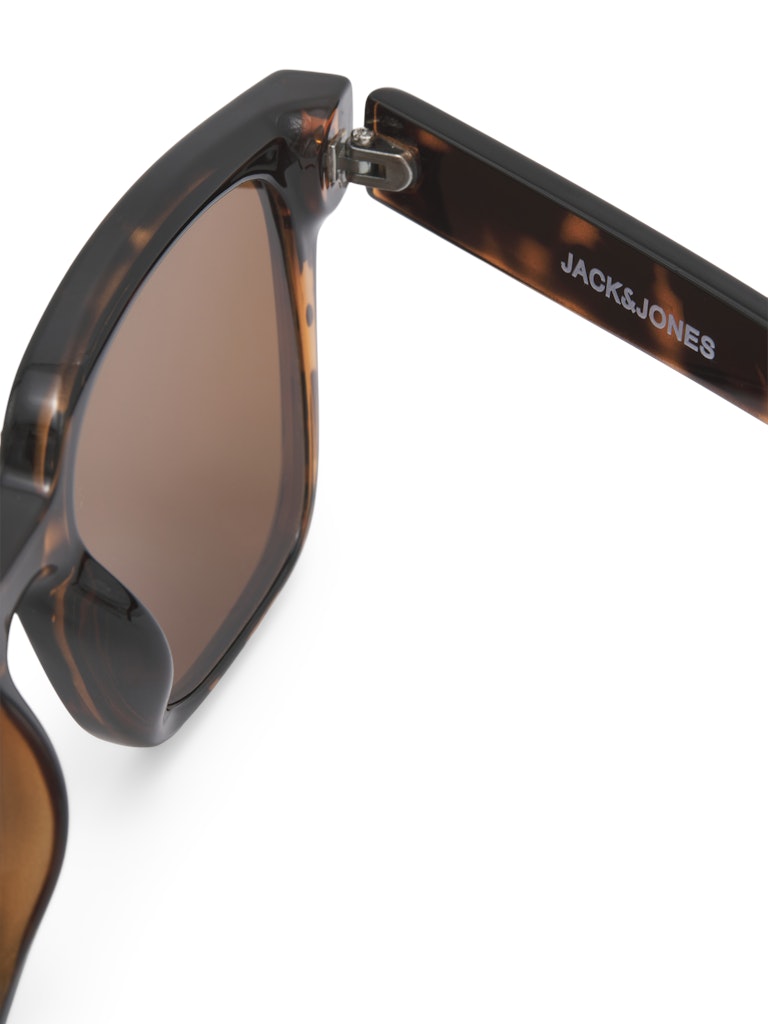 Close-up of tortoiseshell sunglasses with 'Jack & Jones' branding on a white background