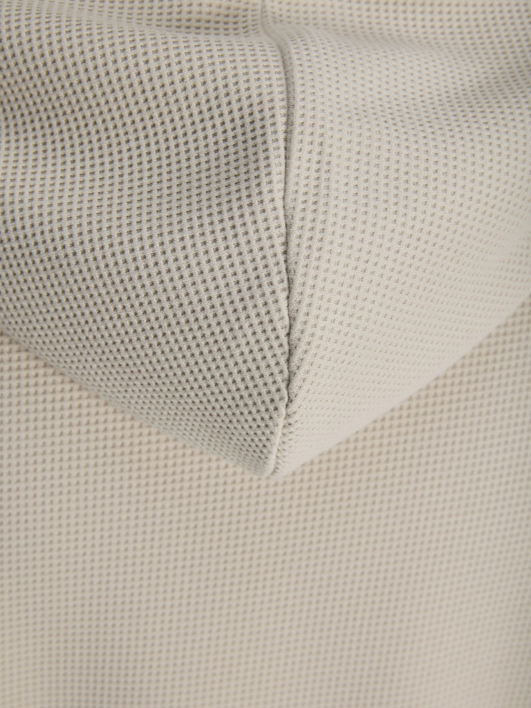 Close-up of beige textured fabric with a subtle pattern