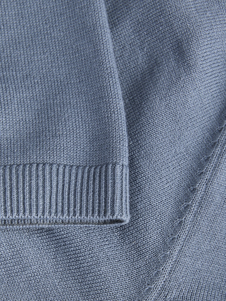 Close-up of a blue polo shirt with ribbed collar and cuffs.