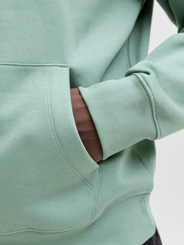Close-up of a light green hoodie with a pocket