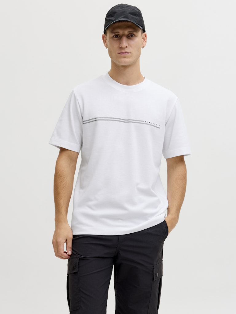 Person wearing a white t-shirt and black cap on a plain background