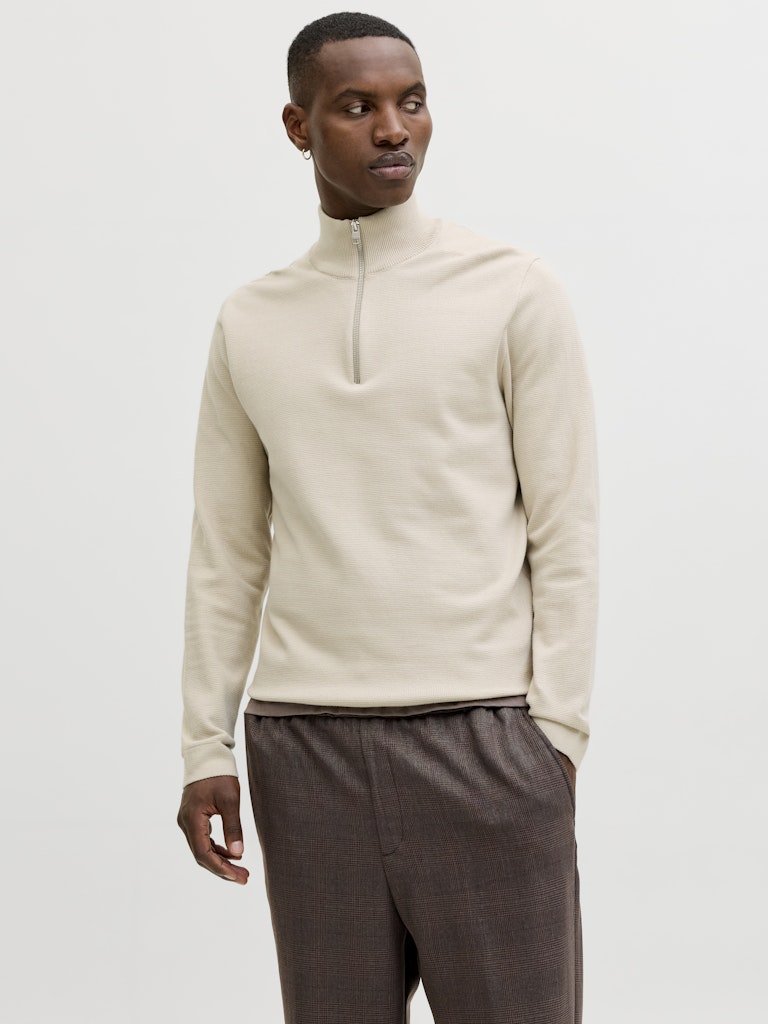 Man wearing cream knit half zip sweater