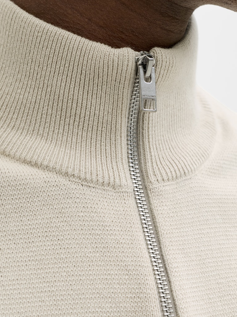 Close-up of a beige sweater with a zipper