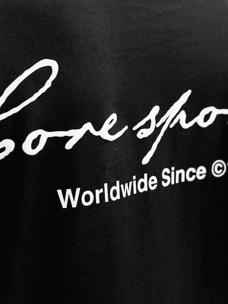 Black t-shirt with white text 'Coresport Worldwide Since 1990' on a black background