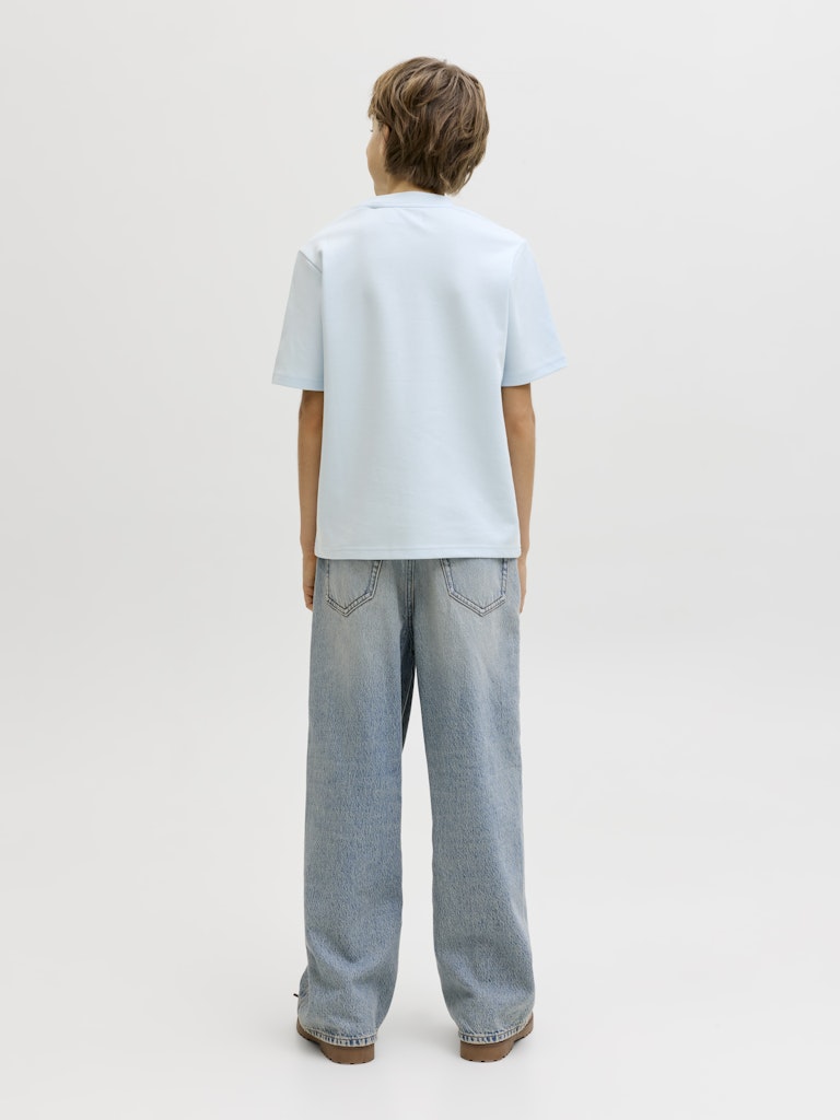Person wearing a light blue t-shirt and light gray jeans on a white background