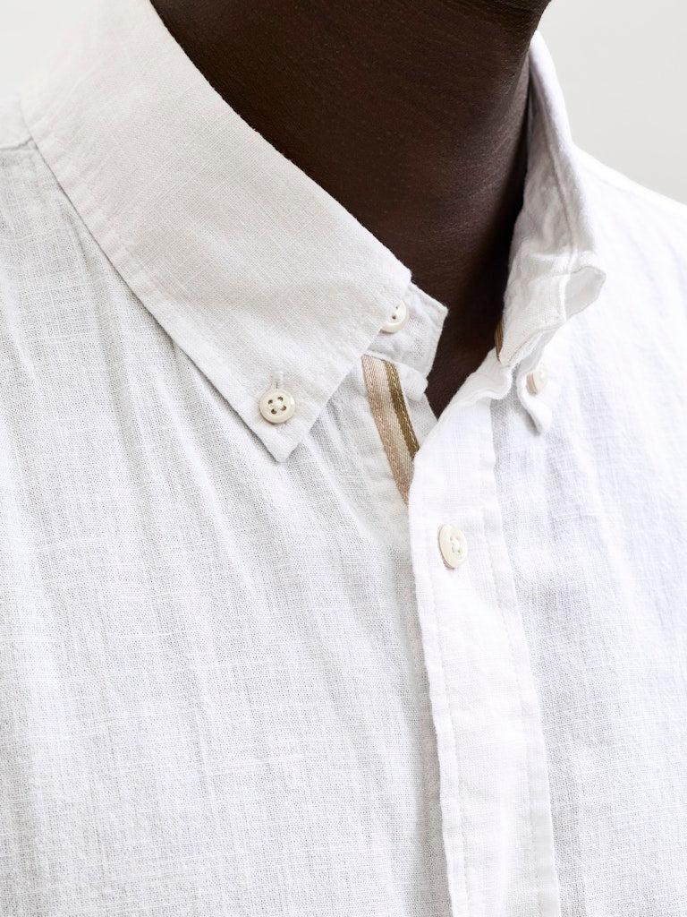 Close-up of a white button-up shirt with a collar.