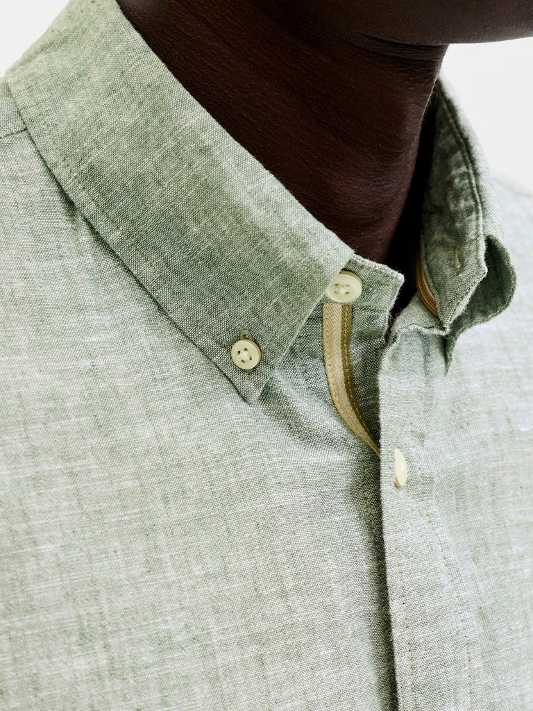 Close-up of a green shirt with buttons and collar details