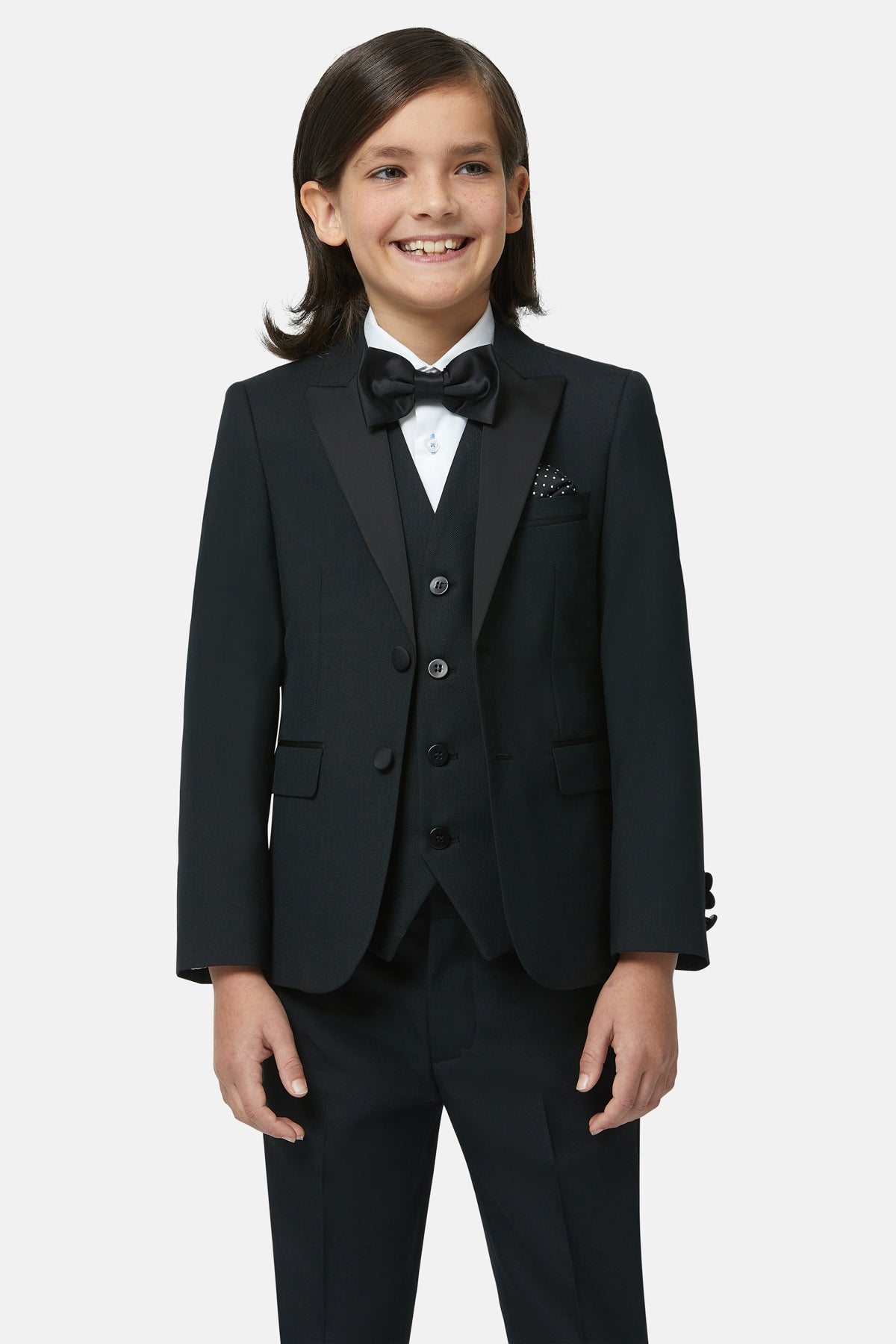 Child wearing a black suit with a bow tie on a white background and a black waistcoat