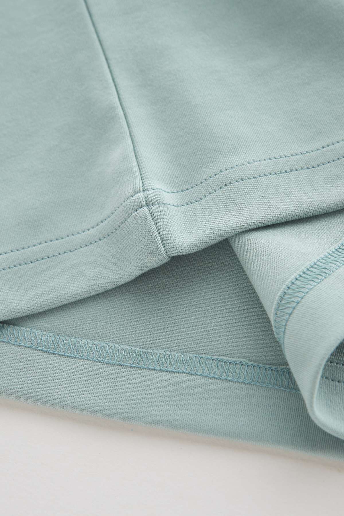 Close-up of light blue fabric with a focus on texture and stitching.