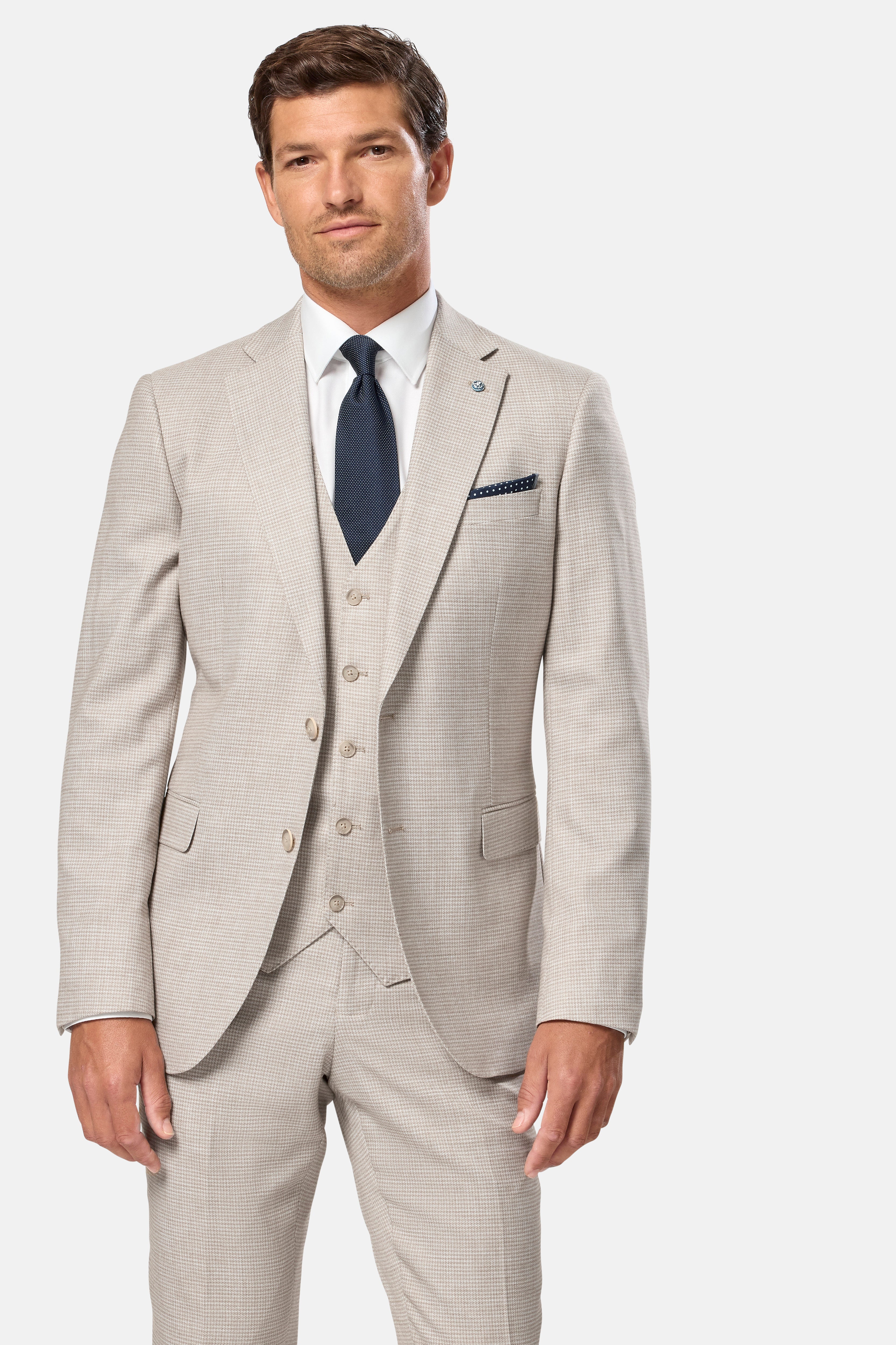 Man wearing a light stone suit with a blue tie on a white background