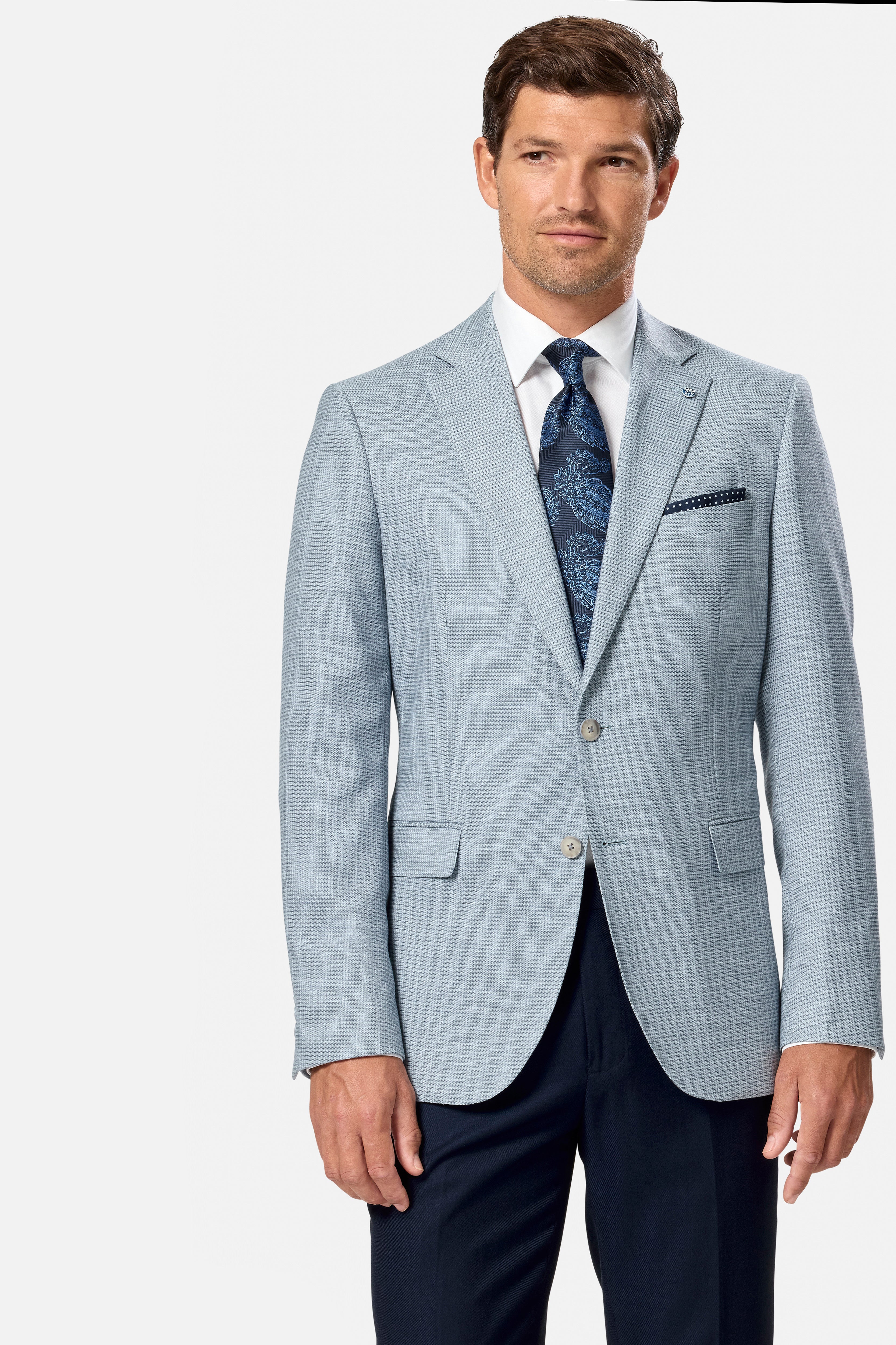 Man wearing a light blue checkered suit with a white shirt and patterned tie on a white background