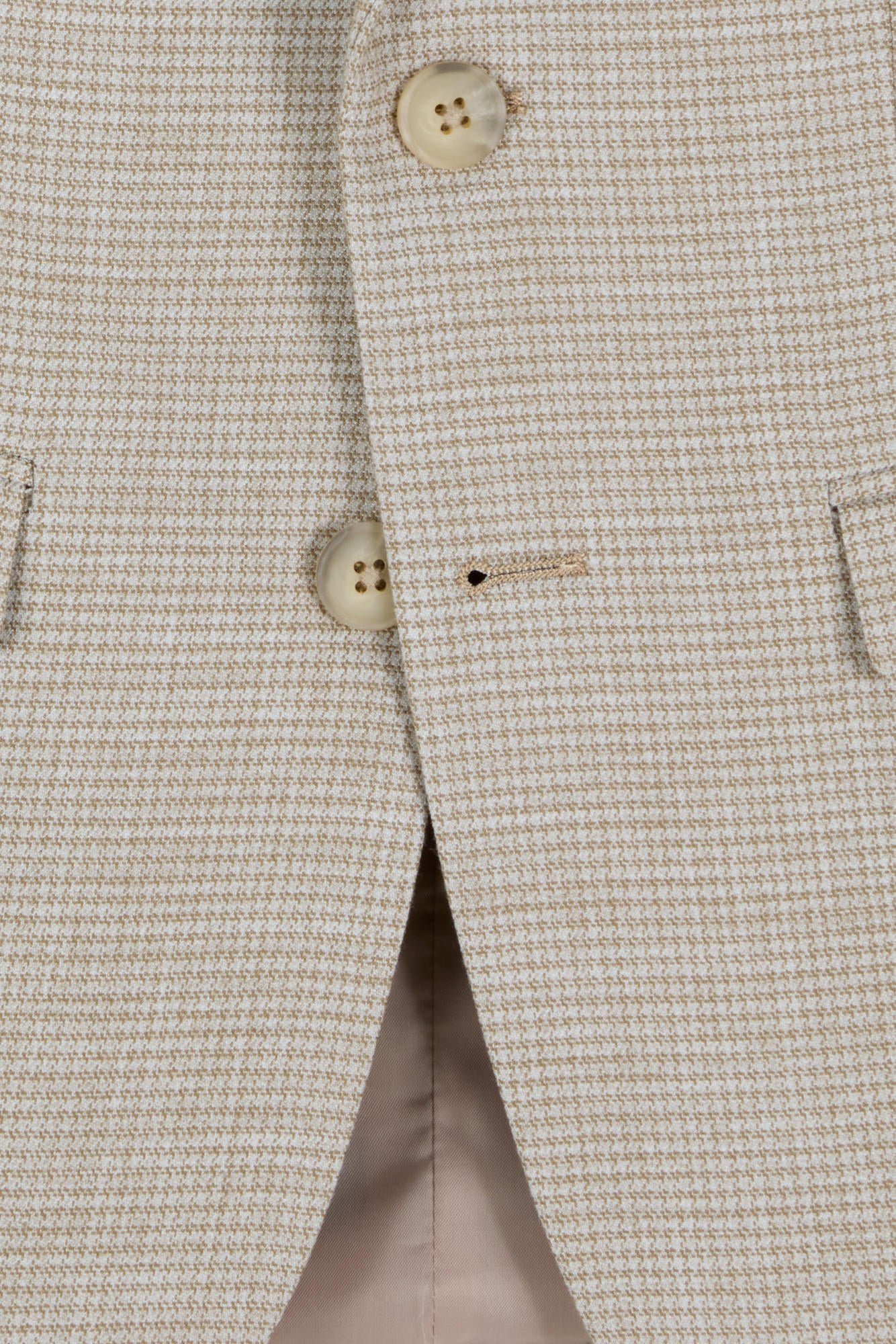 Close-up of a beige textured boys blazer with buttons