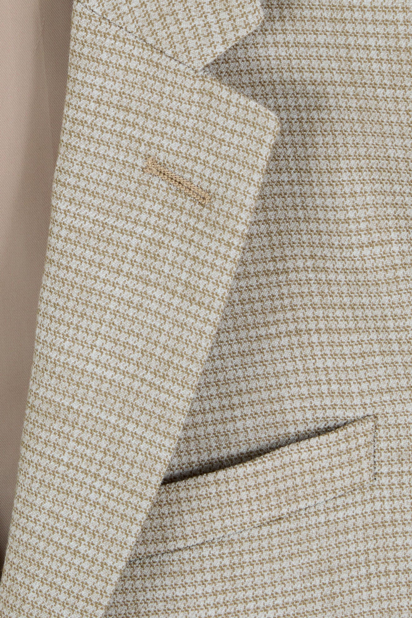 Close-up of a textured fabric with a brand label on a neutral background