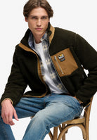 Superdry Mountain Full Zip Fleece in Surplus Goods Olive/Deep Brown seated model view