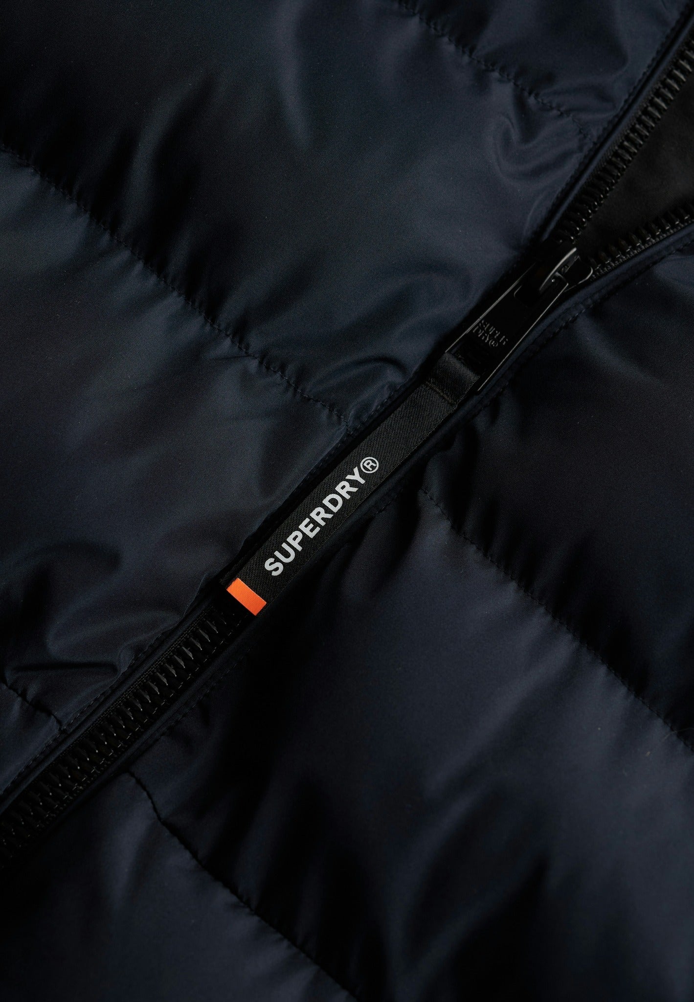 Superdry Hooded Sports Puffer Jacket - Eclipse Navy in Eclipse Navy/Eclipse Navy zip detail angled view