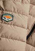 Superdry Fuji Midweight Padded Jacket in Buckwheat Beige logo patch detail