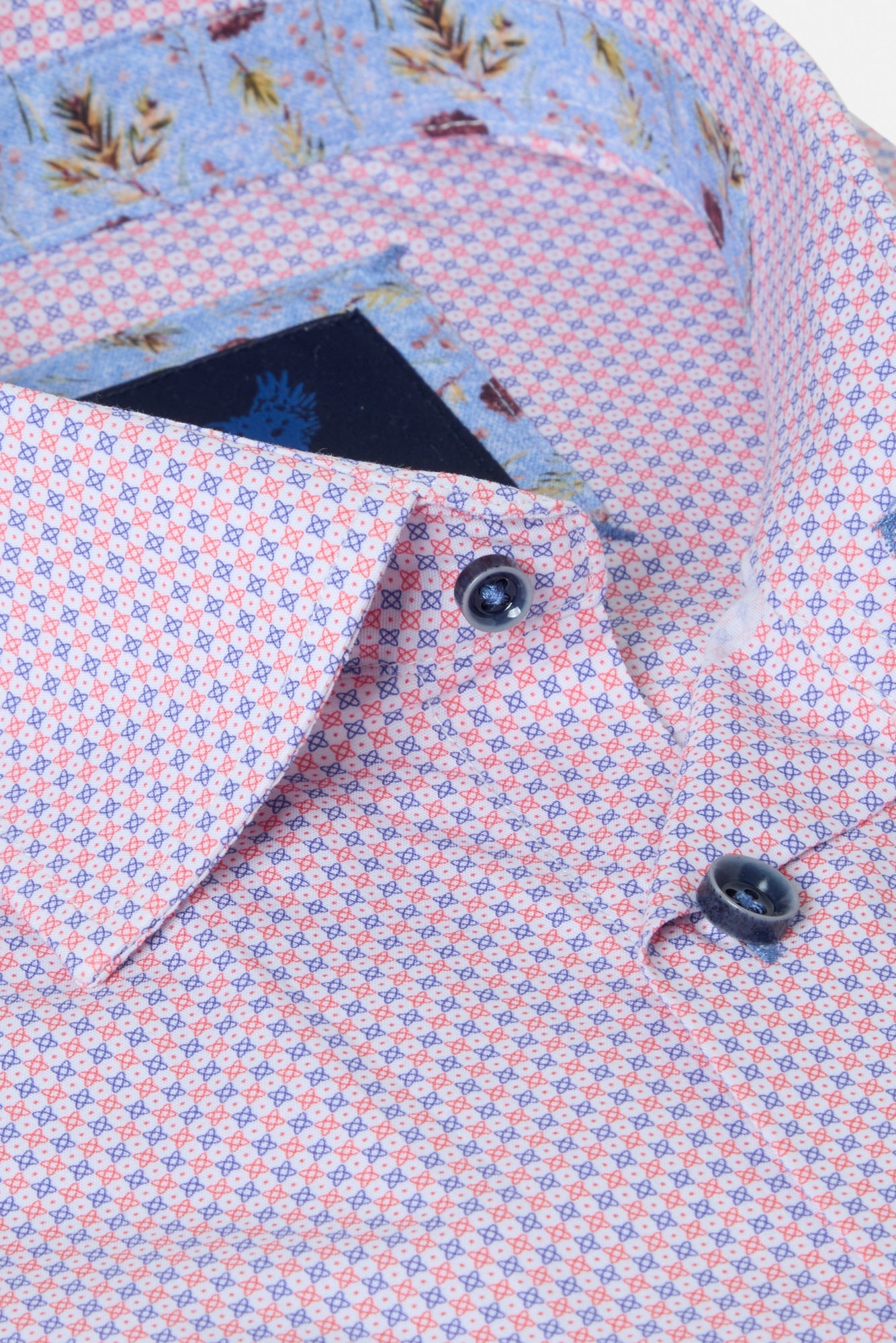 Close-up of a patterned shirt with floral details on a white background