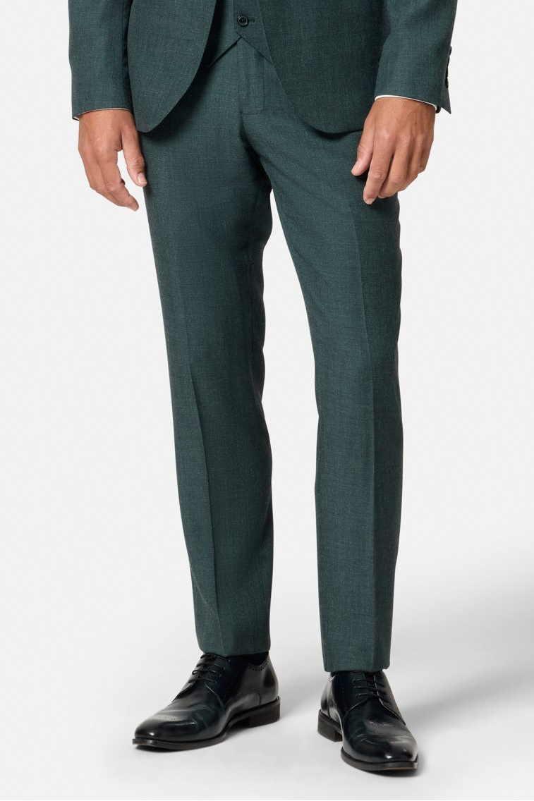 Green suit trousers with black shoes on a white background