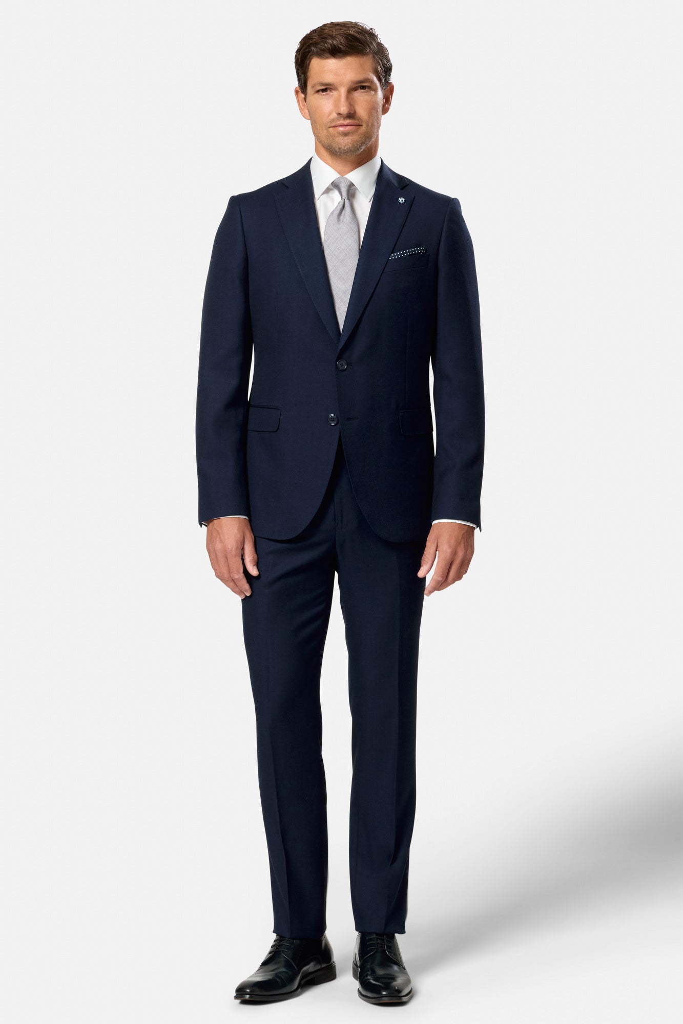 Man wearing a navy blue suit with a white shirt on a white background