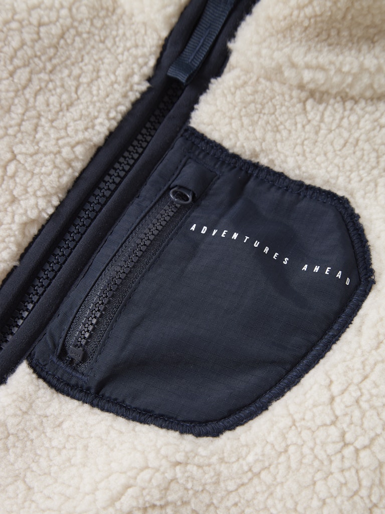 Navy blue waist bag with 'Adventures Ahead' text on a beige sherpa background