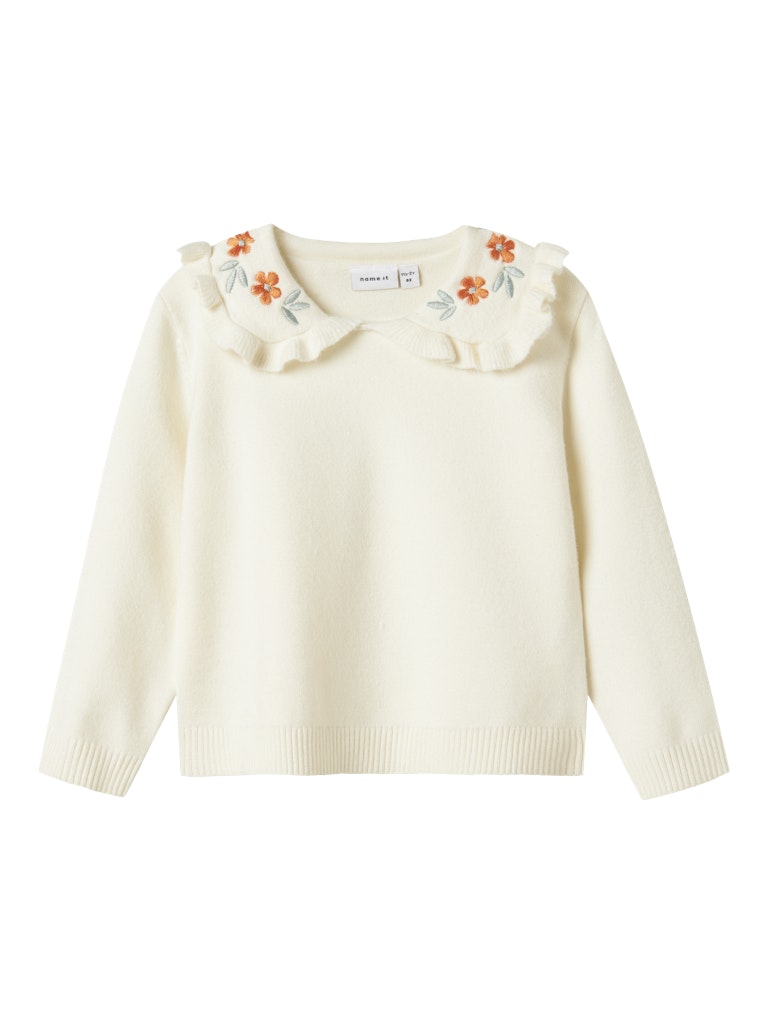 White sweater with floral embellishments on a white background
