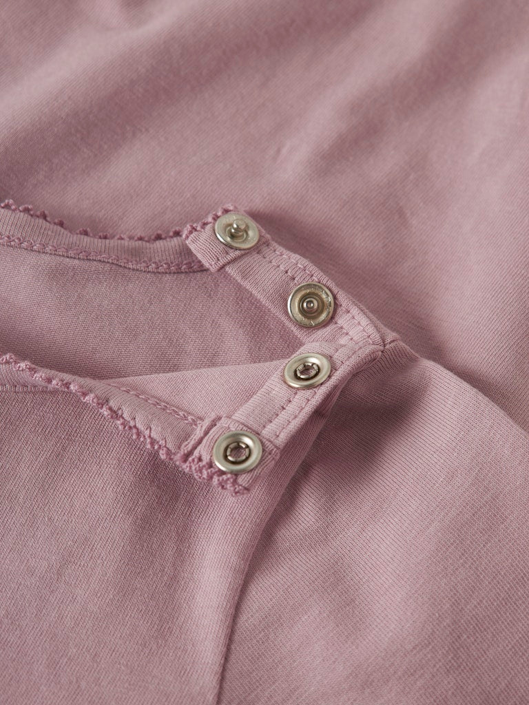 Close-up of a pink garment with button details