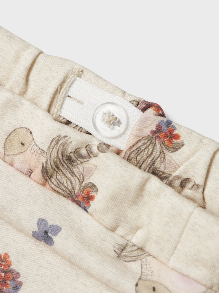 Close-up of pants with embroidered designs on a white background