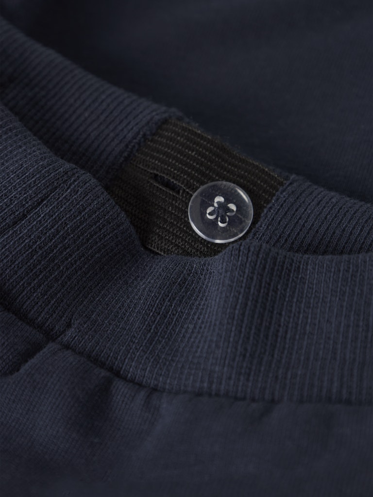 Close-up of a navy blue garment with a button detail