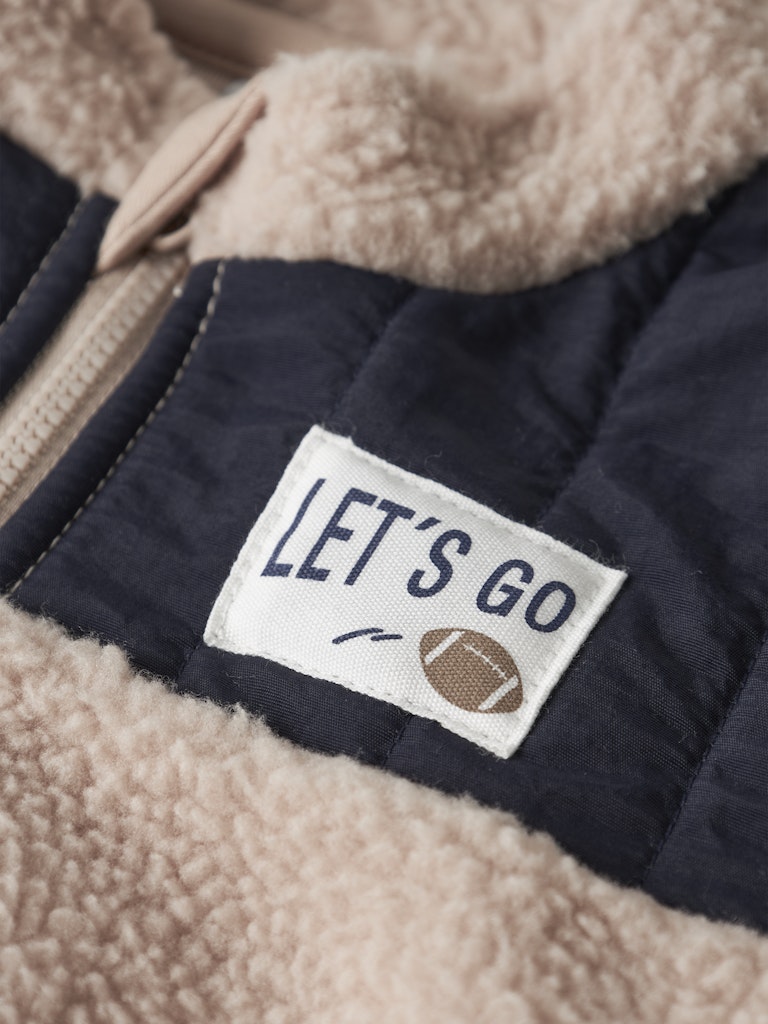Beige jacket with a 'Let's Go' label and football graphic on a beige fleece background