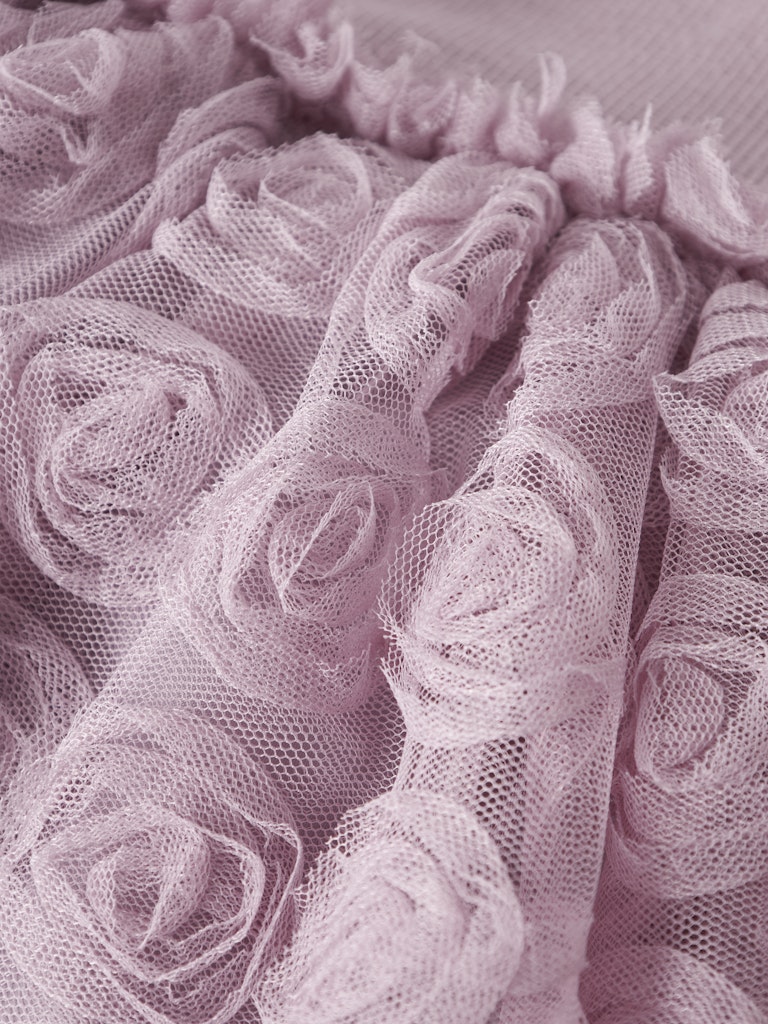Close-up of pink tulle fabric with floral patterns