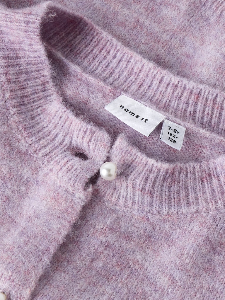Close-up of a pink knitted sweater with a brand label and pearl detail.