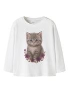 A white long-sleeve t-shirt featuring a graphic print of a cute gray tabby kitten sitting among dark pink flowers, displayed against a solid white background.