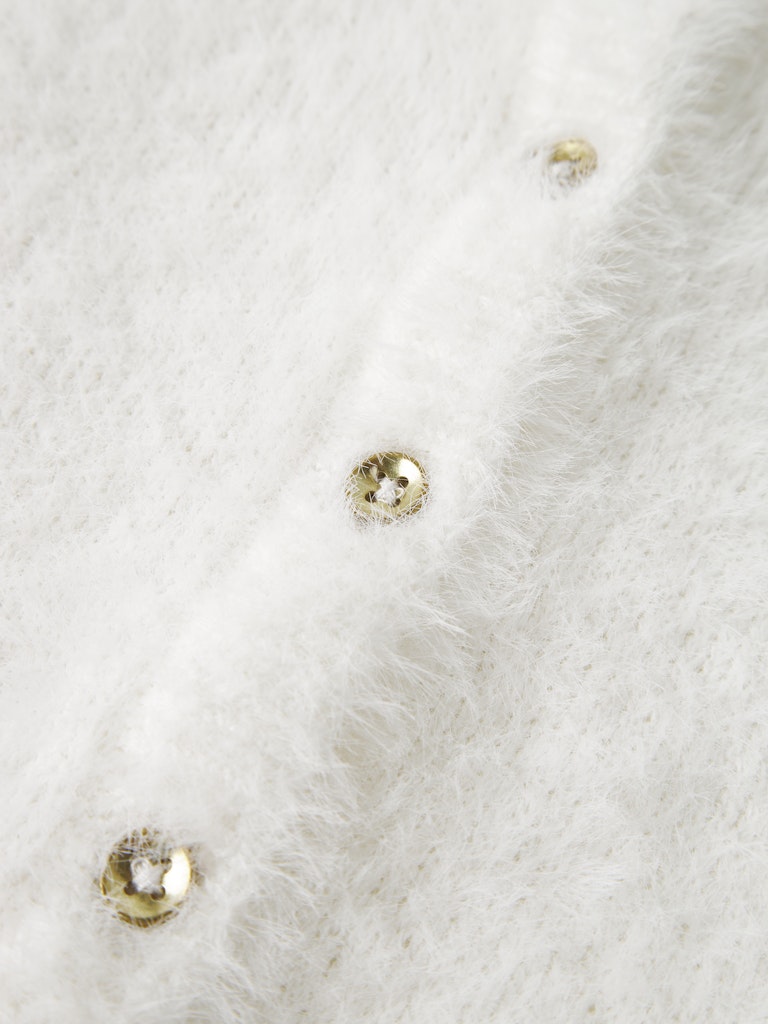 Close-up of a white textured fabric with gold buttons