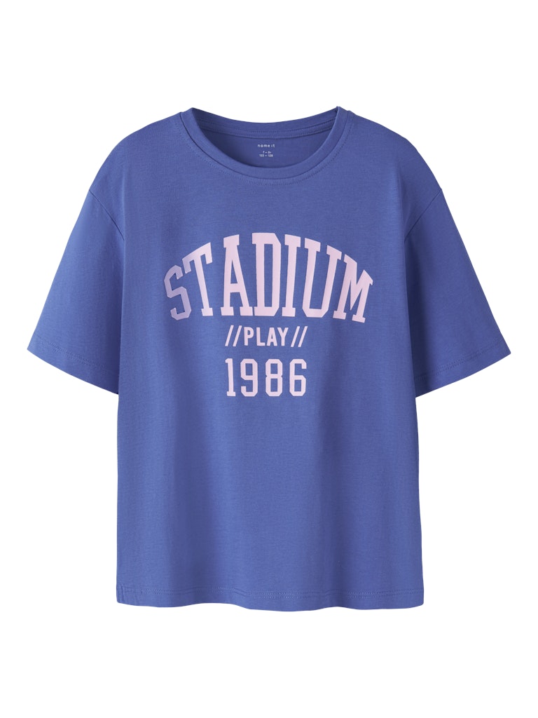 Blue t-shirt with 'STADIUM // PLAY // 1986' text on a white background