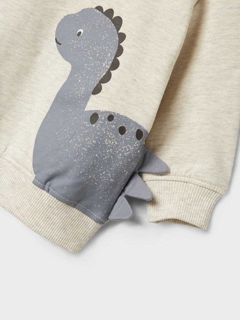 Children's sweater with a dinosaur design on a beige background