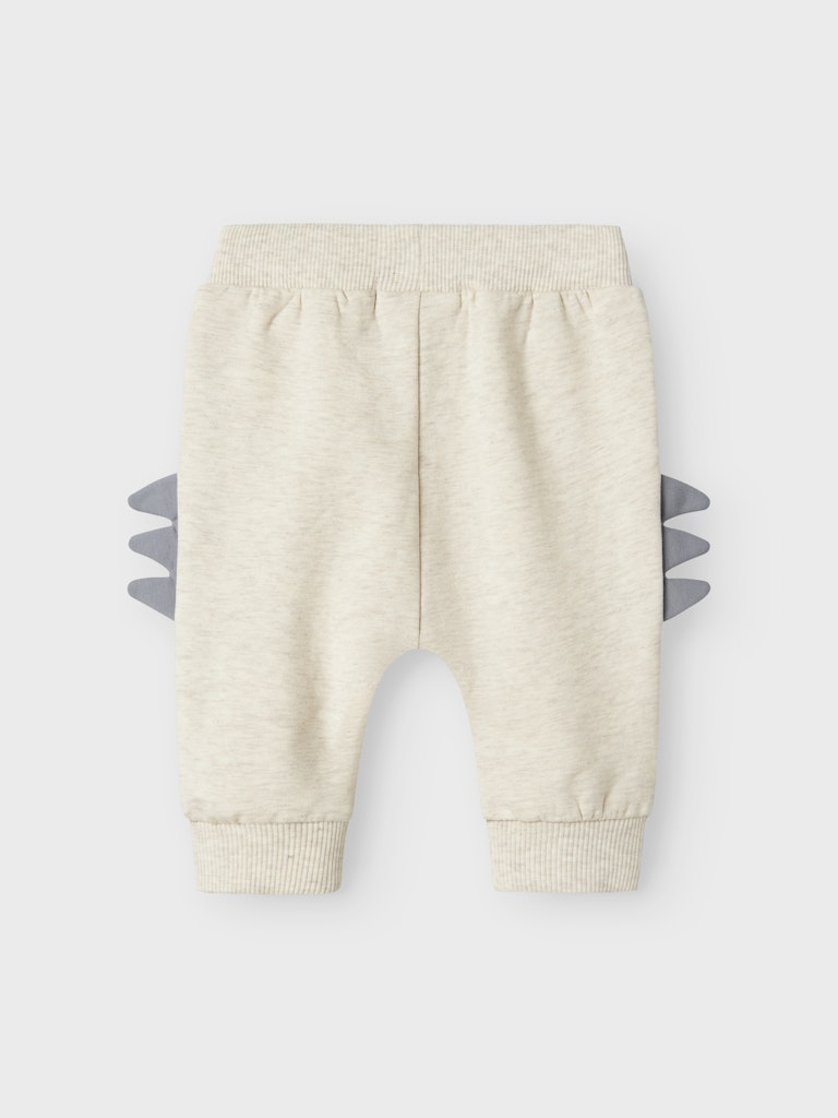 Beige baby pants with gray dinosaur spike design on a white background